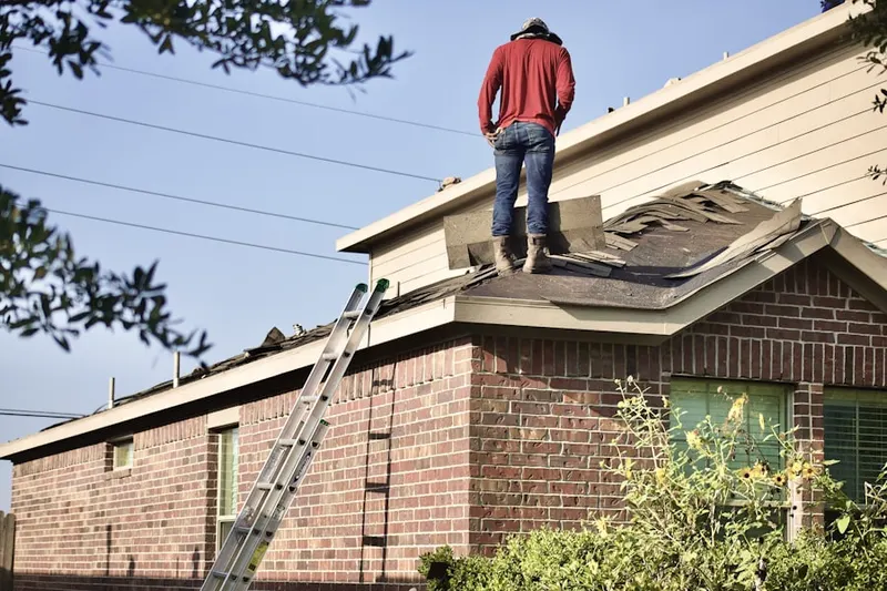 Professional roofer working on a residential roof in Holiday West